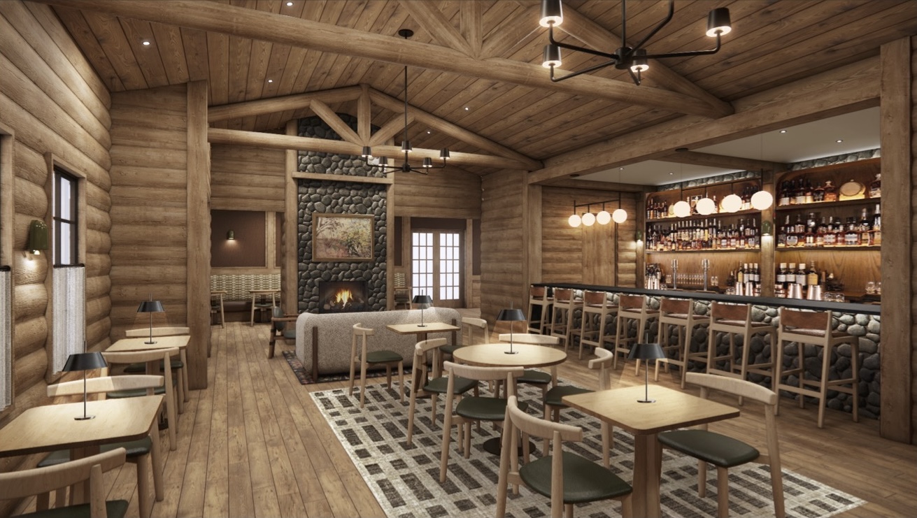 A cozy log cabin-style restaurant interior with wooden walls, a stone fireplace, tables and chairs, and a bar with stools and shelves of bottles.